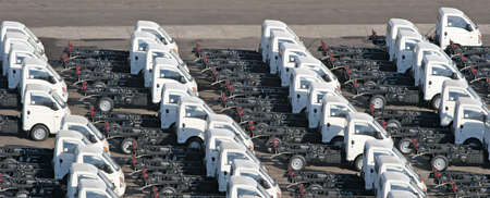 Rows of identical trucks lined up on a pierの写真素材