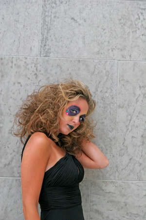 A makeup model in front of a grey wall in black dressの写真素材