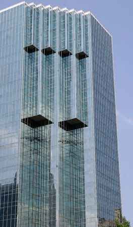 A modern glass office building against the skyの写真素材