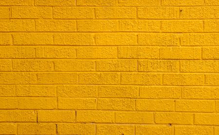 A brightly painted yellow brick wallの写真素材