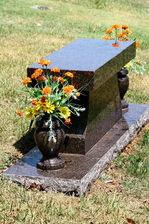 A polished marble headstone and flowers in a cemeteryの写真素材