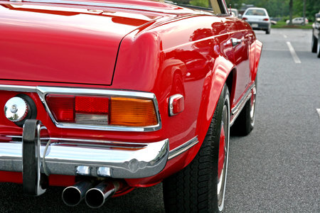 The rear and side of a classic red convertible