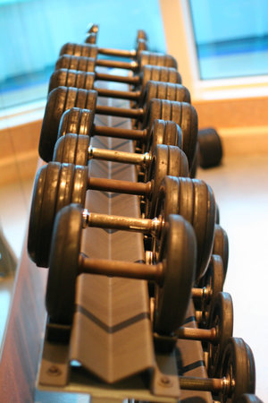 A weight rack in a gym showing rows of dumbbellsの写真素材