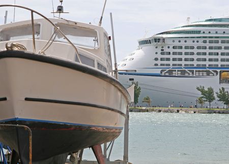 A small boat in dry dock and a large cruise shipの写真素材
