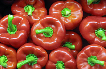 Red bell peppres with green stems in a vegetable market