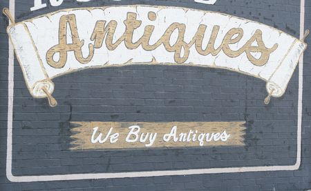 An old faded sign advertising antiquesの写真素材