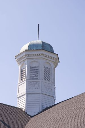 An old and tarnished cupola against blue skyの写真素材