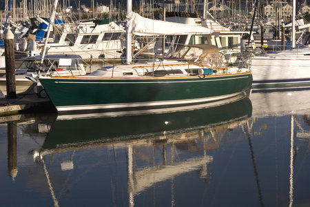 A nice green boat tied up at a marina