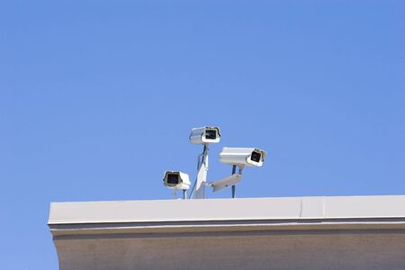 A cluster of security cameras on a rooftopの写真素材