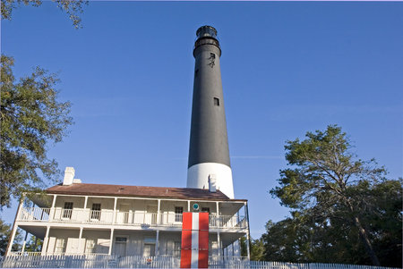 Black and white lighthouse at Pensacola behind houseの写真素材