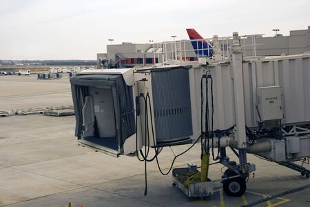 A jetway at a busy airport waiting for the next airplaneの写真素材
