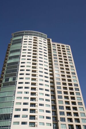 A modern condo high rise against a blue skyの写真素材