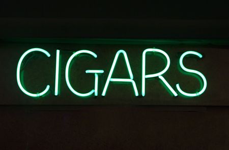 A bright green neon Cigars sign against blackの写真素材