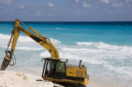 Construction equipment on the beach digging new sand