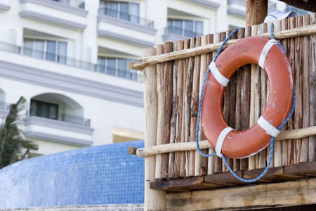 A lifeguards float hanging from a bamboo and thatch hut at a tropical resortの写真素材