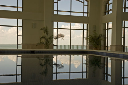 Large windows reflected in the water of a nice indoor swimming pool