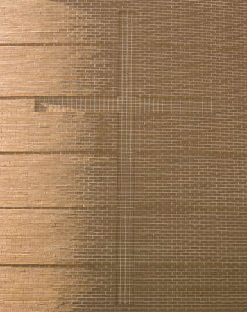 A brick wall on the side of a church with a cross embeddedの写真素材