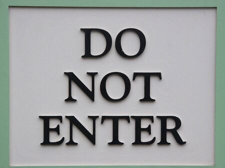A white and green sign with black letters Do Not Enterの写真素材