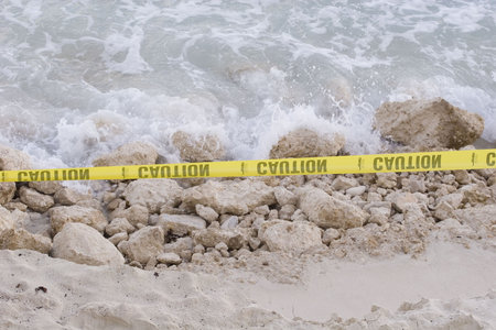 Major beach erosion making it dangerous to use. Yellow caution tape has been strung in place