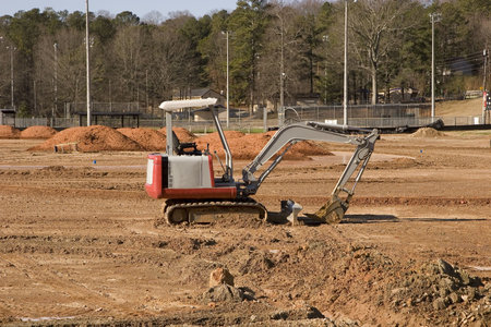 A small front end loader working in a field of dirt