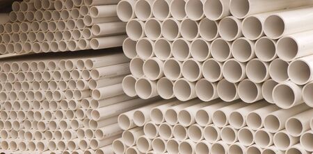 Stacks of plastic pvc plumbing pipes at a construction siteの写真素材