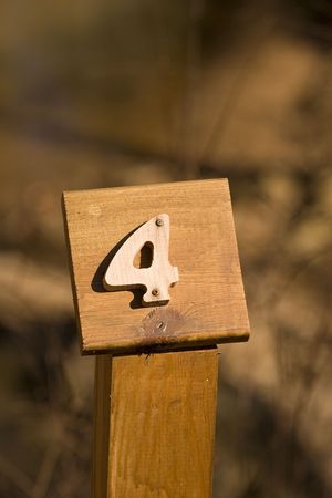 A mile marker on a woodland trail showing number fourの写真素材