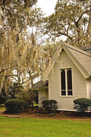 An old small church under oak trees hanging with spanish mossの写真素材