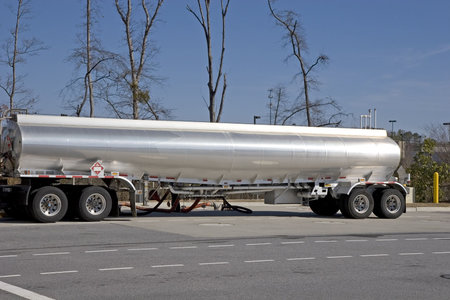 A tanker truck dispensing fuel at a gasoline station