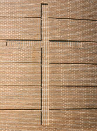 A cross built into a brick wall of a churchの写真素材