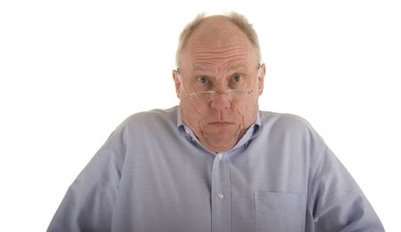 An older guy in a blue shirt and glasses shrugging his shouldersの写真素材