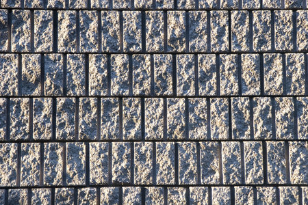 A rough block wall sidelit from the early morning sun
