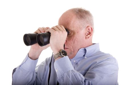 An older guy in a blue shirt looking to the right through binocularsの写真素材