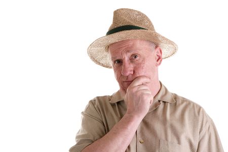 An older guy in a brown shirt wearing a straw hat with his hand on his chinの写真素材