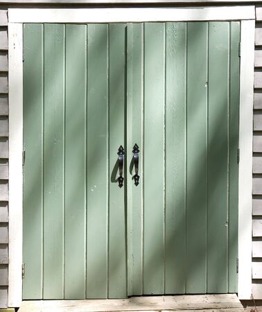 Black Iron Handles on a Green Doorの写真素材
