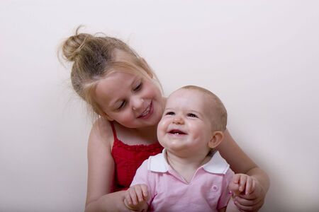 A young girl with a baby girl smiling and laughingの写真素材