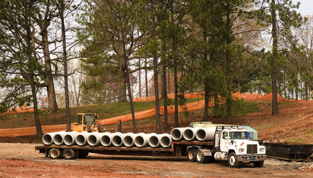 Concrete water pipes lined up on a flatbed truck