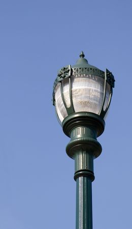 A traditional green street lamp against a blue skyの写真素材