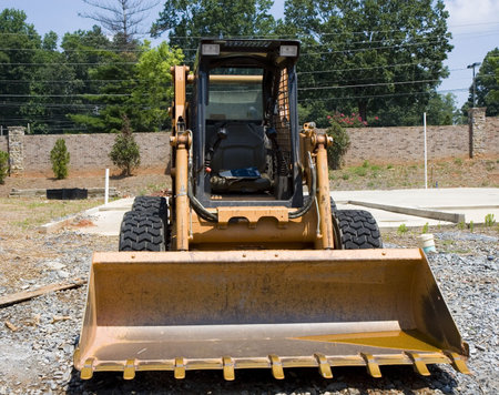 A yellow loader on a job site shot from front
