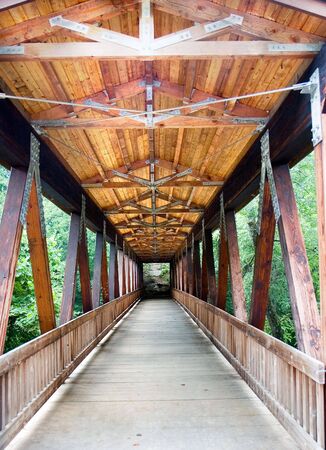 An old wood covered bridge over a riverの写真素材