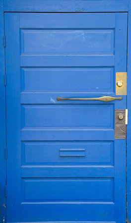 A bright blue door with brass fixtures