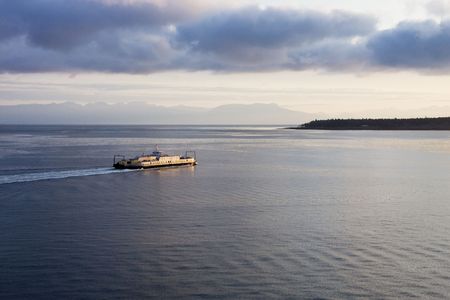 A large commercial ferry boat crossing a calm bay in the early morning lightの写真素材