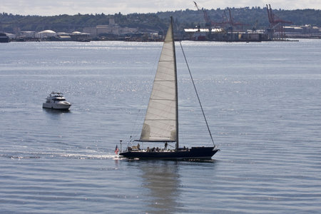 A sailboat moving across calm bay waters
