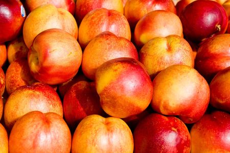 Fresh ripe juicy nectarines in a fruit marketの写真素材