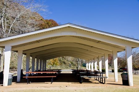 A white pavilion in a park with picnic tables underneathの写真素材