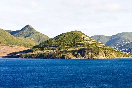 The coast off a tropical island with green islands rising from the blue seaの写真素材