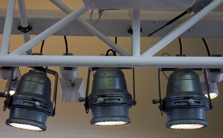 Three industrial spot lights attached to roof trussesの写真素材
