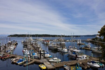 A nice harbor with many boats under a partly cloudy skyの写真素材