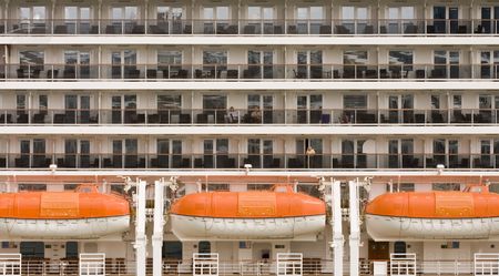 The side of a cruise ship showing balconies and lifeboatsの写真素材
