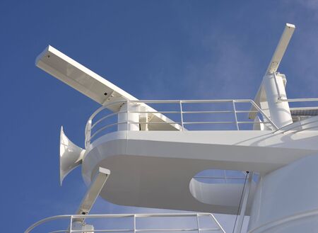 A cruise ship tower with sonar and airhorn against blue skyの写真素材