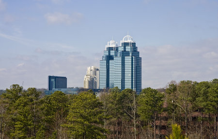 Modern Blue towers rising out of the trees in the distanceの写真素材